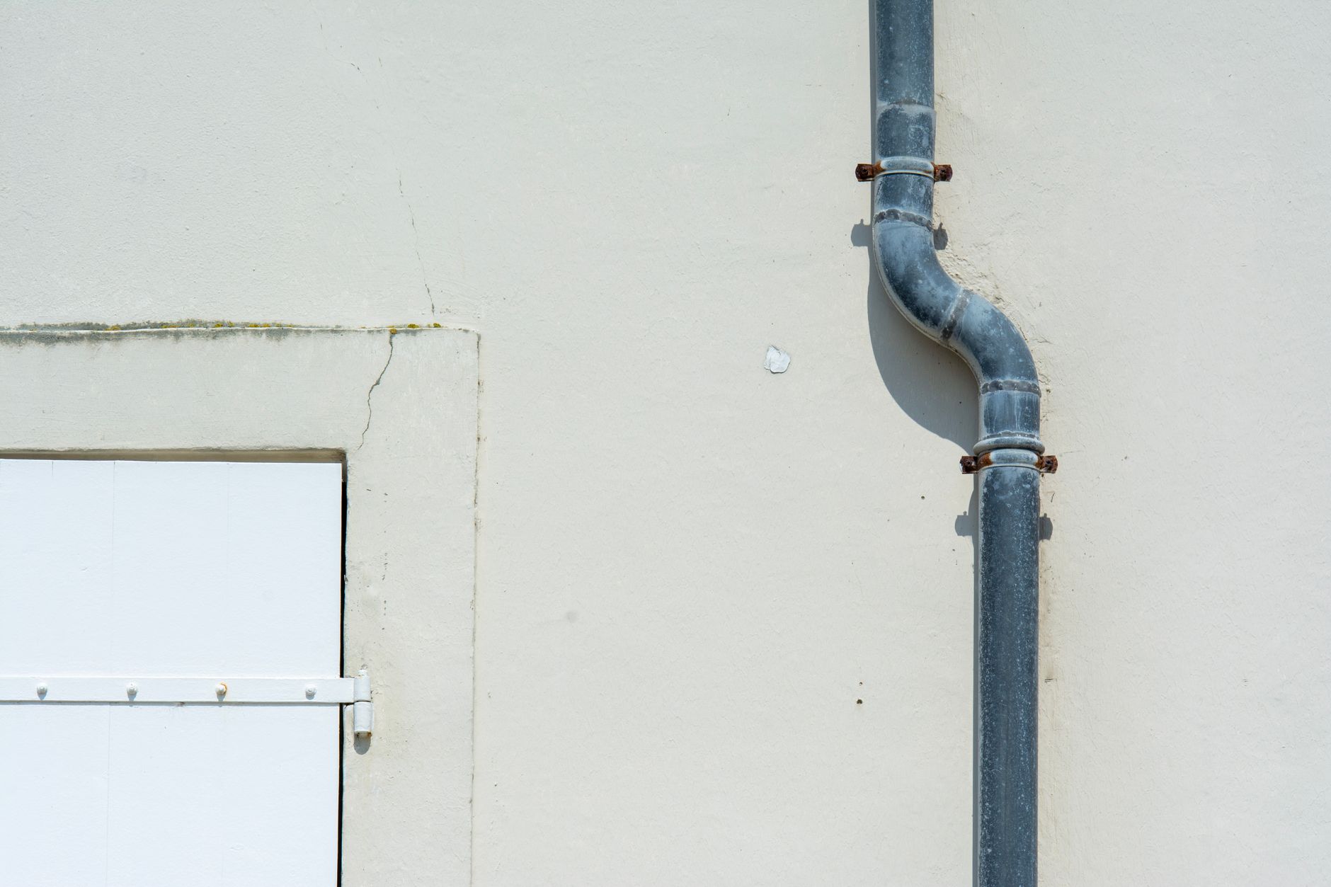 Metal downspout running down the exterior wall of a building
