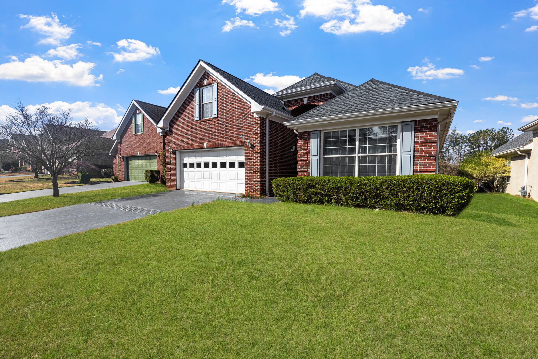 Red brick suburban house with an attached garage and front lawn